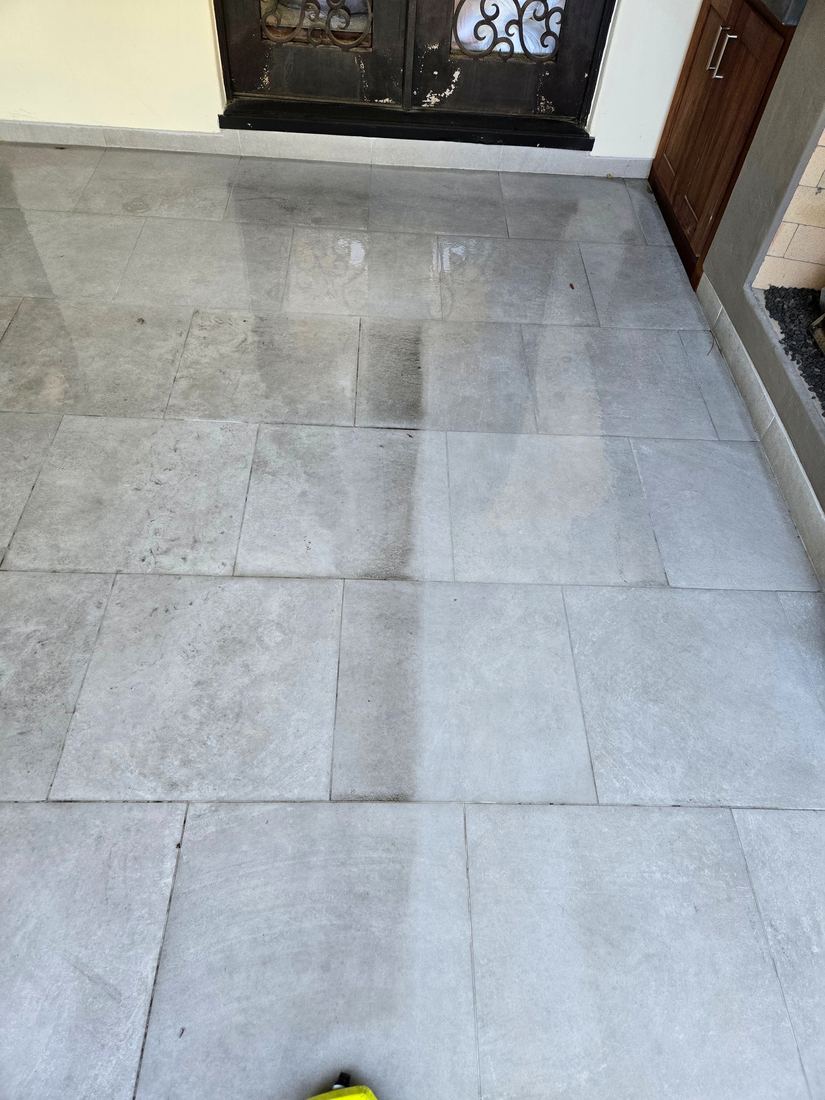 Half-washed porch tile showing the before and after difference
